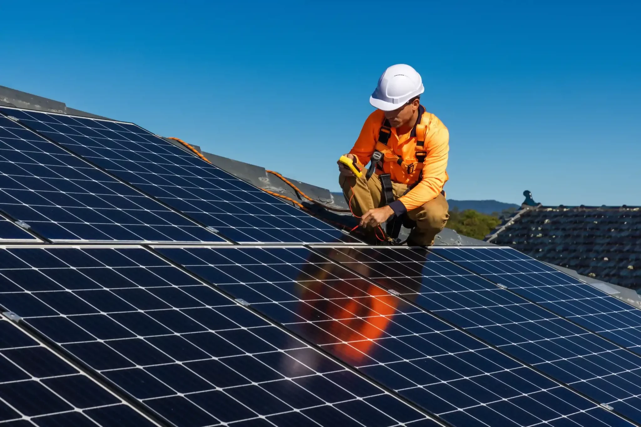 un technicien omeo qualifié rge en train de réaliser une intervention de poser des panneaux solaires sur le toit d'une maison