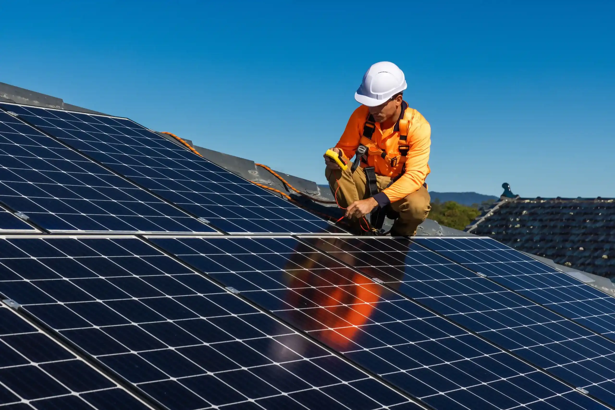 un technicien omeo qualifié rge en train de réaliser une intervention de poser des panneaux solaires sur le toit d'une maison